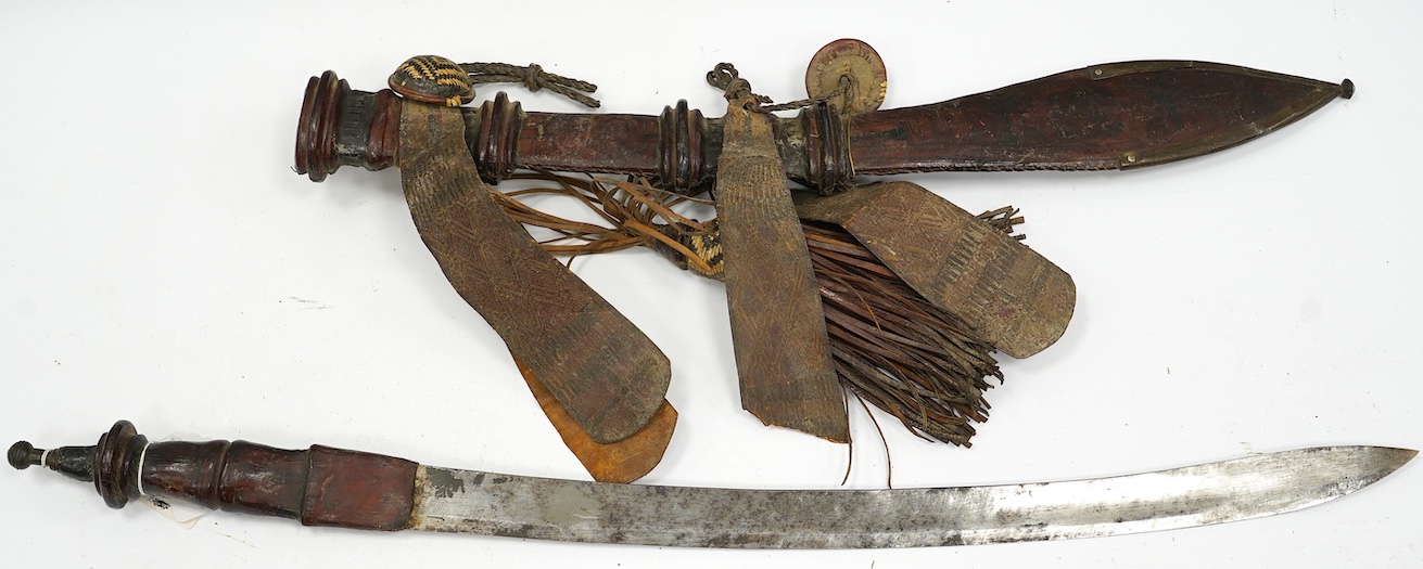 A late 19th century Nigerian Taboura from the Hausa People of Northern Nigeria, in leather scabbard, blade 59.5cm. Condition - good